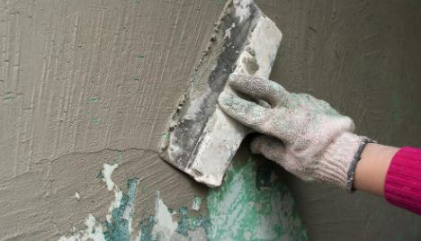 contractor repairing a stucco surface on a home